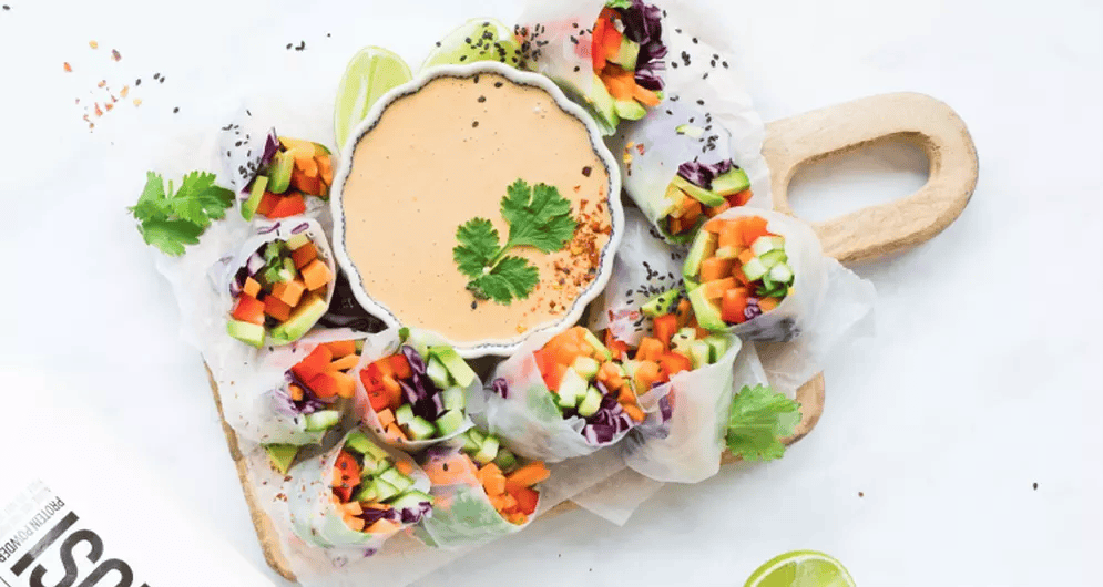 Vegetable spring rolls with dipping sauce on a white plate